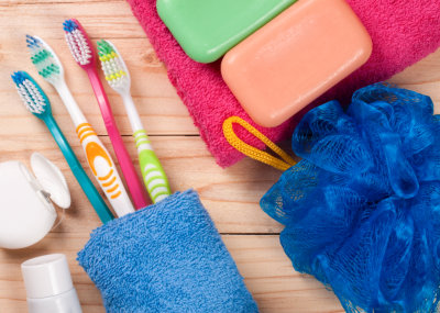 Toothbrushes soap sponge towel on a wooden table. Hygiene products.